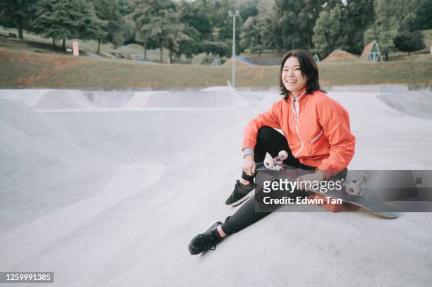 一個年輕的中國女孩在週末在公共滑板公園練習滑板。 - malaysia beautiful girl 個照片及圖片檔