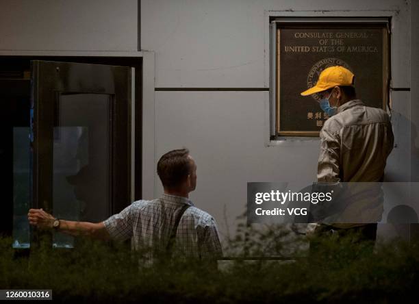 Jim Mullinax , US Consul General in Chengdu, speaks with a worker who removes a plaque of the US Consulate General in Chengdu on July 26, 2020 in...