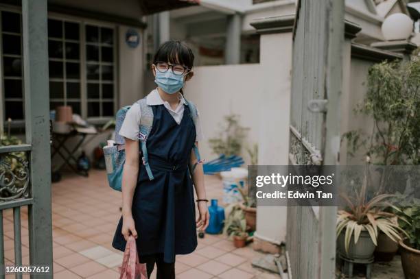 an asian chinese young girl going to school departing from home with facemask as new normal - malaysia school stock pictures, royalty-free photos & images