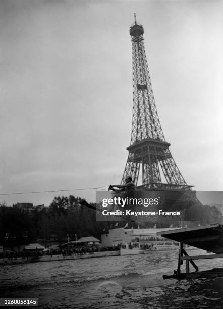 Concours de saut en tremplin en ski nautique au pied de la Tour Eiffel, à Paris, France en septembre 1957.