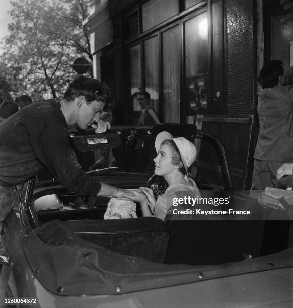 Jean Seberg au volant de sa voiture avec son chien dans une scène du film 'Bonjour Tristesse', à Paris, France le 1er août 1957.