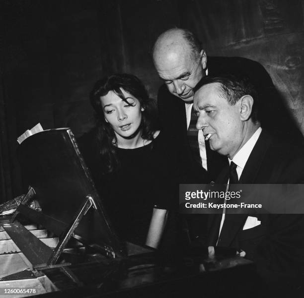 Juliette Gréco interprétant la chanson 'Bonjour Tristesse' sous la conduite de Georges Auric , derrière eux, le metteur en scène Otto Preminger, à...