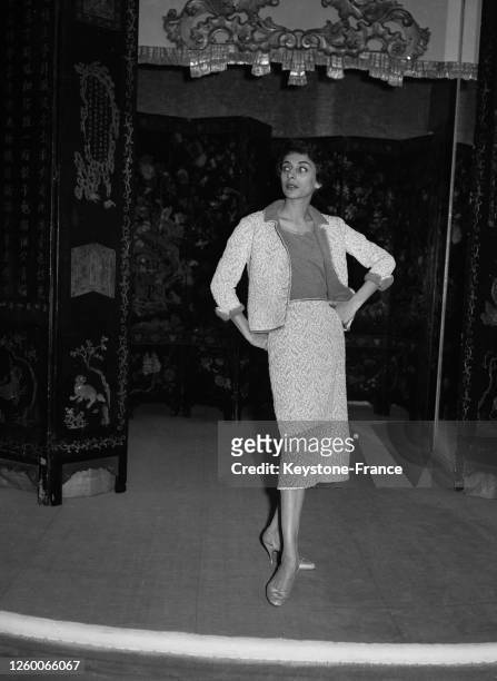 Mannequin présentant un ensemble d'après-midi en toile rebrodée blanche et cognac, composé d'une jupe, d'un corsage en jersey et d'une courte veste...