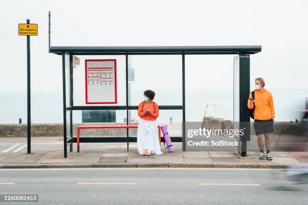 waiting at bus stop - bus stop stock pictures, royalty-free photos & images