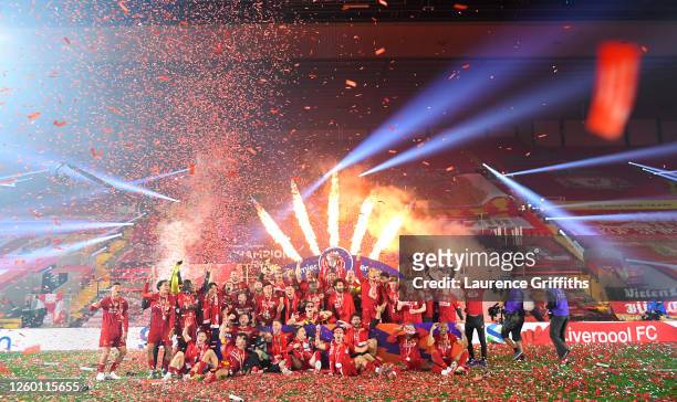 Jordan Henderson of Liverpool holds the Premier League Trophy aloft as the team celebrate winning the League during the presentation ceremony of the...