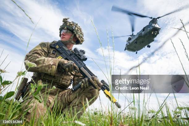 Private Patrick Rodgers of the Anglian Regiment, 2nd Battalion maintains the perimeter as a Chinook helicopter carries out a medical evacuation...