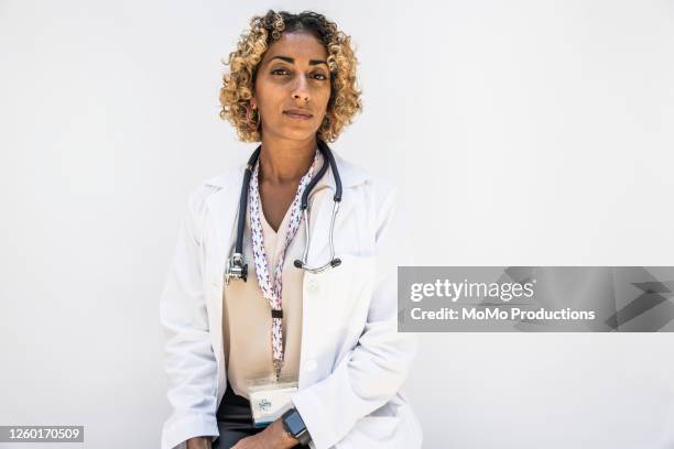 studio portrait of female doctor/healthcare worker - encuadre de tres cuartos fotografías e imágenes de stock