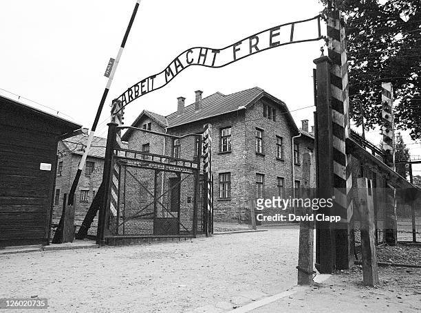 entrance gate with hypocritcal 'in work there is freedom' banner, birkenau concentration camp, auschwitz, poland - auschwitz foto e immagini stock