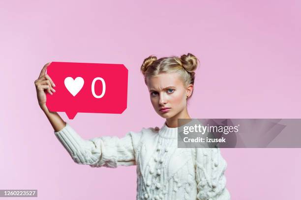 displeased teenege girl holding speech bubble in hand - offense stock pictures, royalty-free photos & images