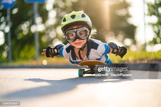 スケートボード上のクローズアップ小さな男の子 - flying goggles ストックフォトと画像