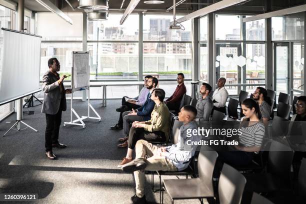 businessman doing a presentation to a team - auditorium stock pictures, royalty-free photos & images