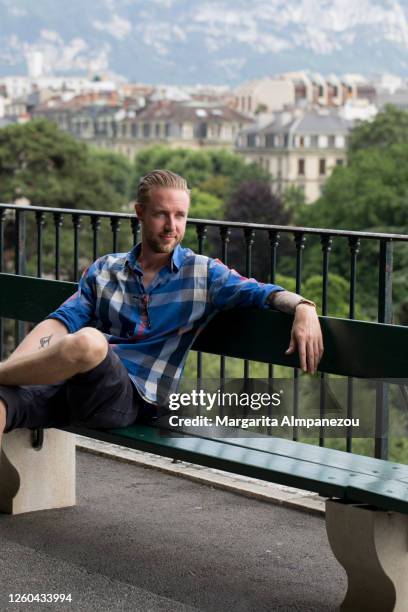 portrait of young man sitting on a bench in geneva - geneva switzerland stock pictures, royalty-free photos & images