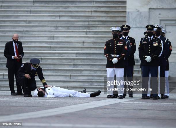 Member of the military honor guard passes out shortly before the flag-draped casket of Rep. John Lewis is to be carried into the U.S. Capitol where...