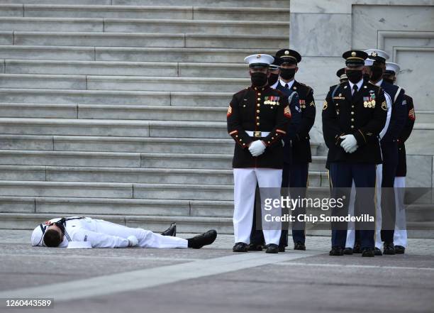 Member of the military honor guard passes out shortly before the flag-draped casket of Rep. John Lewis is to be carried into the U.S. Capitol where...