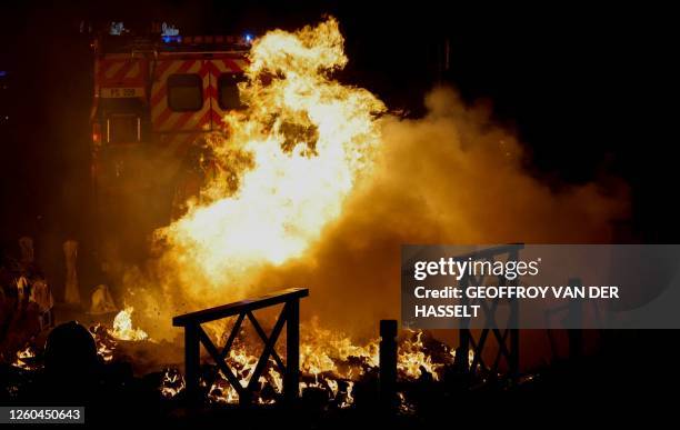 Firefighter extinguishes the flames of a car set on fire during protests in Nanterre, west of Paris, on the early hours of June 29 a day after the...