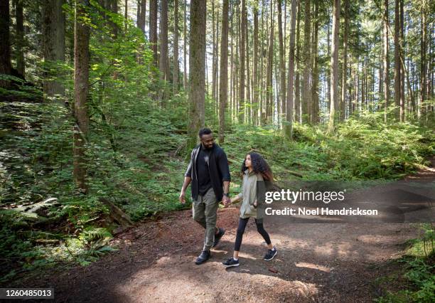 dad smiling to his daughter on the forest trail - familie vor wald stock-fotos und bilder