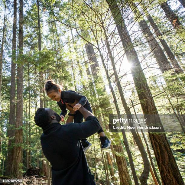 dad and daughter smiling together in the park - family and happiness and diverse ストックフォトと画像