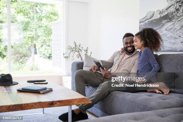 father and daughter bonding with tablet device - die neue normalität stock-fotos und bilder