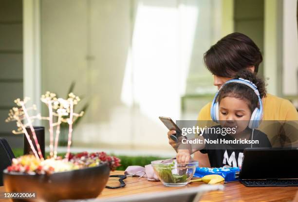 mother distracts her daughter with digital tablet and snacks - distracts stock pictures, royalty-free photos & images