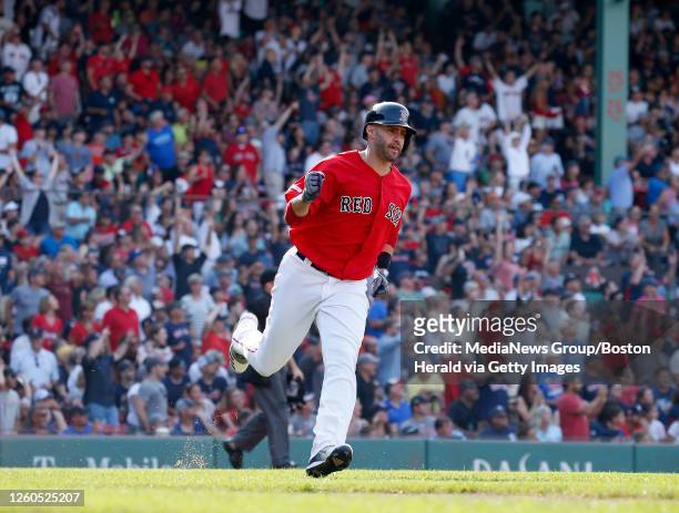 Boston Red Sox's J.D. Martinez pumps his fist as he runs the bases after hitting a two-run home run scoring Rafael Devers during the fourth inning of...