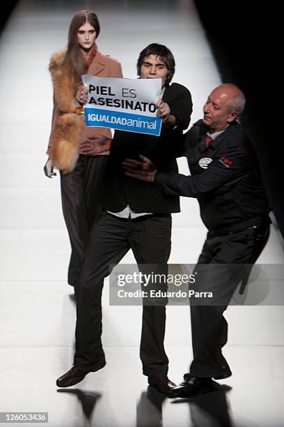 Animals rights campaigners protest against the use of fur on the runway with the slogan 'fur is murder' during the Ion Fiz - Maria Escote Fashion...
