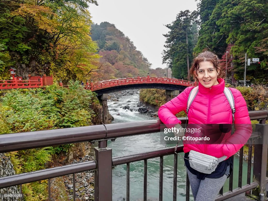 Woman posing in front of Nikko National Park river and bridge