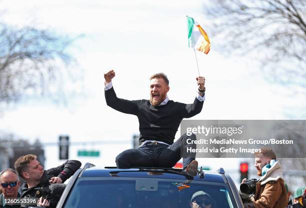 Fighter Conor McGregor waves an Irish flag from the roof of a vehicle during the St. Patrick's Day Parade on March 17, 2019 in South Boston,...