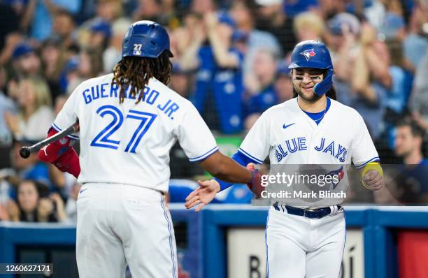 Bo Bichette of the Toronto Blue Jays celebrates scoring with Vladimir Guerrero Jr. #27 against the San Francisco Giants in the first inning at the...