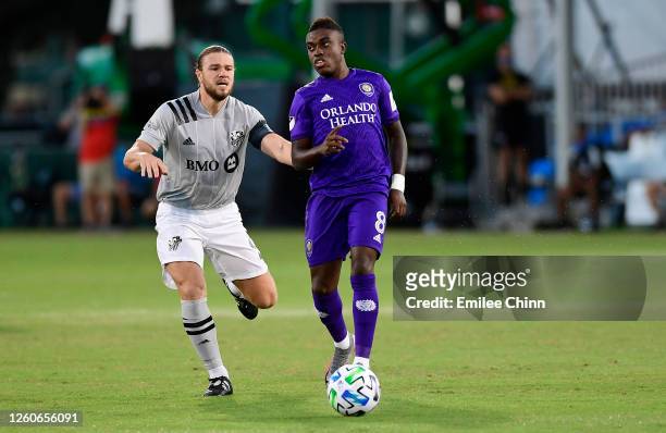 Sebas Mendez of Orlando City carries the ball past Samuel Piette of Montreal Impact during the Knockout Round of the MLS IS Back Tournament at ESPN...