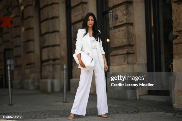 Rebecca Mir wearing Max Mara suit and bag, Atelier Swarovski jewelry and Midnight 00 heels on July 21, 2020 in Munich, Germany.