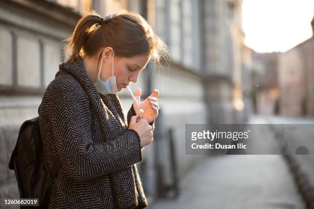 smoking cigarettes with mask - smoking issues stock pictures, royalty-free photos & images