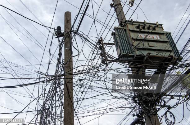 electricity tranformer and chaotic electrical and fibre optic cabling on power poles in an urban street - out of service stock pictures, royalty-free photos & images