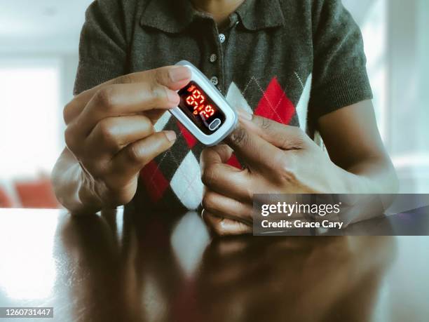 woman uses pulse oximeter - taking pulse stock pictures, royalty-free photos & images