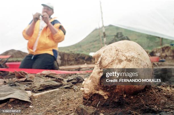 An expert from the Guatemalan Anthropology Foundation examines a bone 14 February during the exhumation of an estimated 300 bodies of people killed...