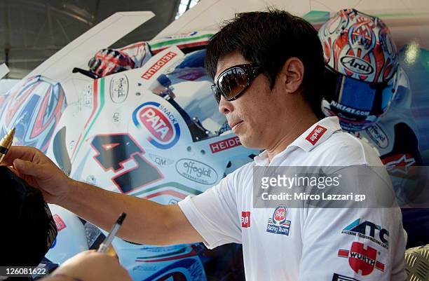 Noriyuki Haga of Japan and PATA Racing Team Aprilia signs autographs for fans during an autograph signing session at the Paddock Show during the...