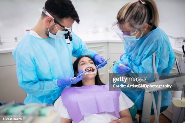 dentiste travaillant sur le patient dans le studio dentaire. - bridge photos et images de collection