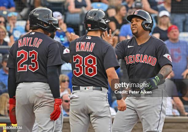 Jose Ramirez of the Cleveland Guardians celebrates grand his slam with Steven Kwan and Bo Naylor in the third inning against the Kansas City Royals...