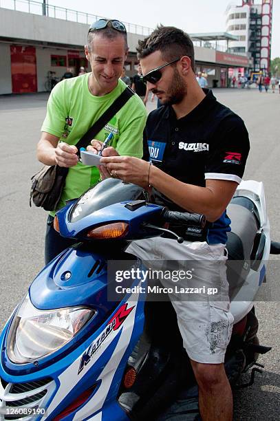 Michel Fabrizio of Italy and Team Suzuki Alstare signs autographs for fans during an autograph signing session at the Paddock Show during the...