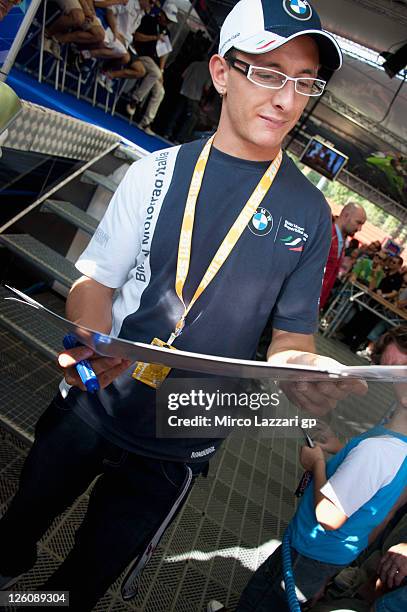 Sylvain Barrier of France and BMW Motorrad Italia Superstock signs autographs for fans during an autograph signing session at the Paddock Show during...