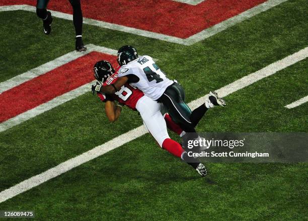 Tony Gonzalez of the Atlanta Falcons carries Jarrad Page against the Philadelphia Eagles for a touchdown at the Georgia Dome on September 18, 2011 in...