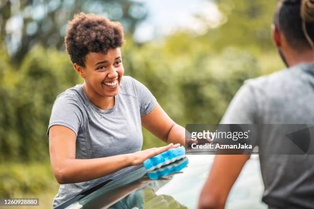 close up of a mixed race woman washing the car - afro man washing stock pictures, royalty-free photos & images