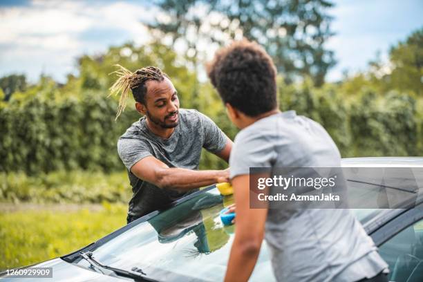 close up of a mixed race woman washing the car - afro man washing stock pictures, royalty-free photos & images