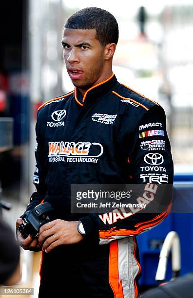 Darrell Wallace, Jr., driver of the U.S. Army Toyota stands in the garage after practice for the NASCAR K&N Pro Series East New Hampshire 100 at New...