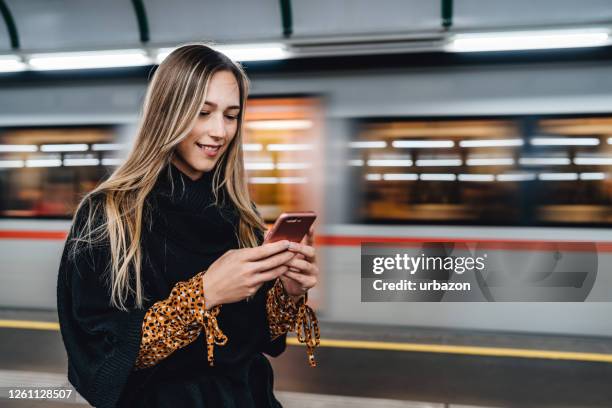 frau überprüft fahrplan am telefon - smartphone im zug stock-fotos und bilder