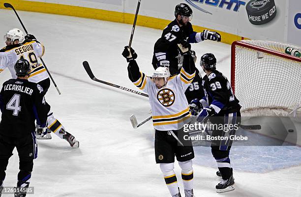 The Bruins Chris Kelly, right, Tyler Sequin, far left, celebrate after Seguin's shot slid very slowly behind Lightning goalie Dwayne Roloson and...