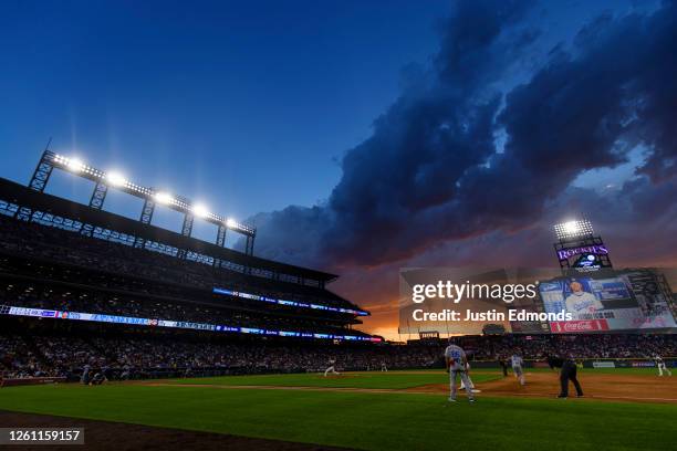 The sun sets behind the stadium as Jake Bird of the Colorado Rockies pitches to Mookie Betts of the Los Angeles Dodgers in the sixth inning at Coors...