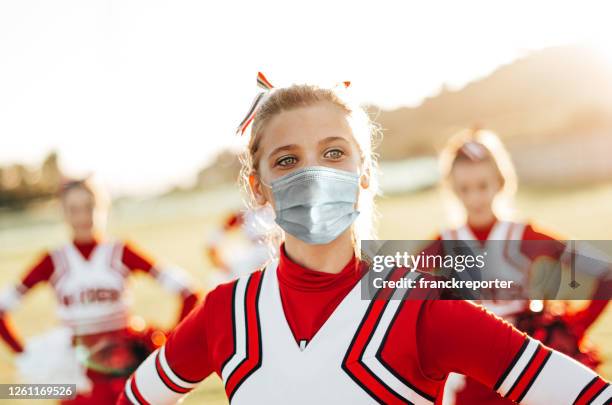 cheerleader beim sport mit gesichtsmaske - teen cheerleader stock-fotos und bilder