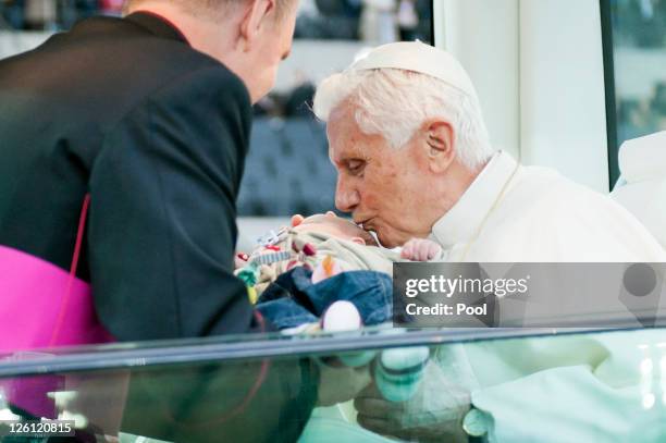 In this photo provided by the German Government Press Office private secretary Georg Gaenswein hands over a baby to Pope Benedict XVI during a...