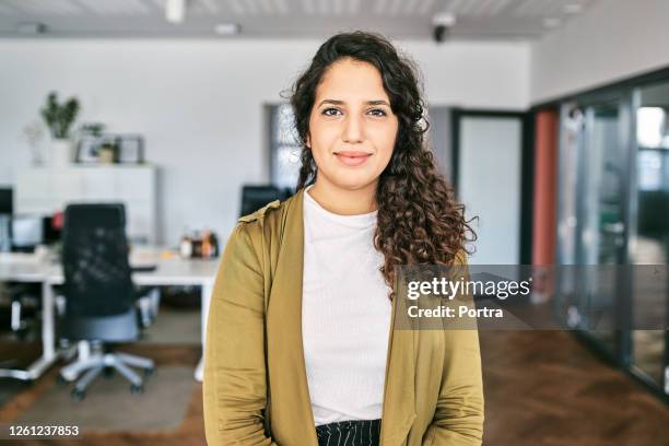 confident young businesswoman in creative office - arab woman portrait stock pictures, royalty-free photos & images