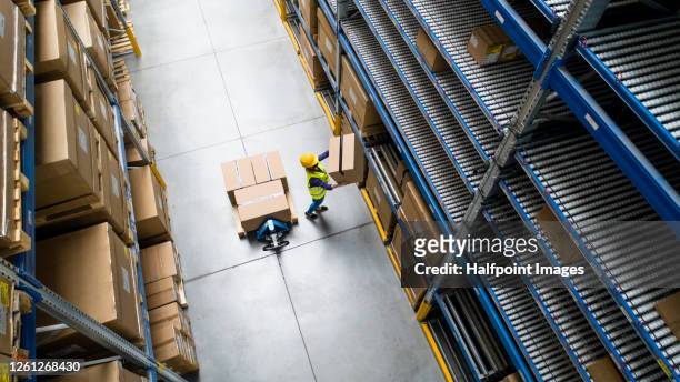 aerial view of woman worker with face mask working in warehouse. - freight transportation stock pictures, royalty-free photos & images